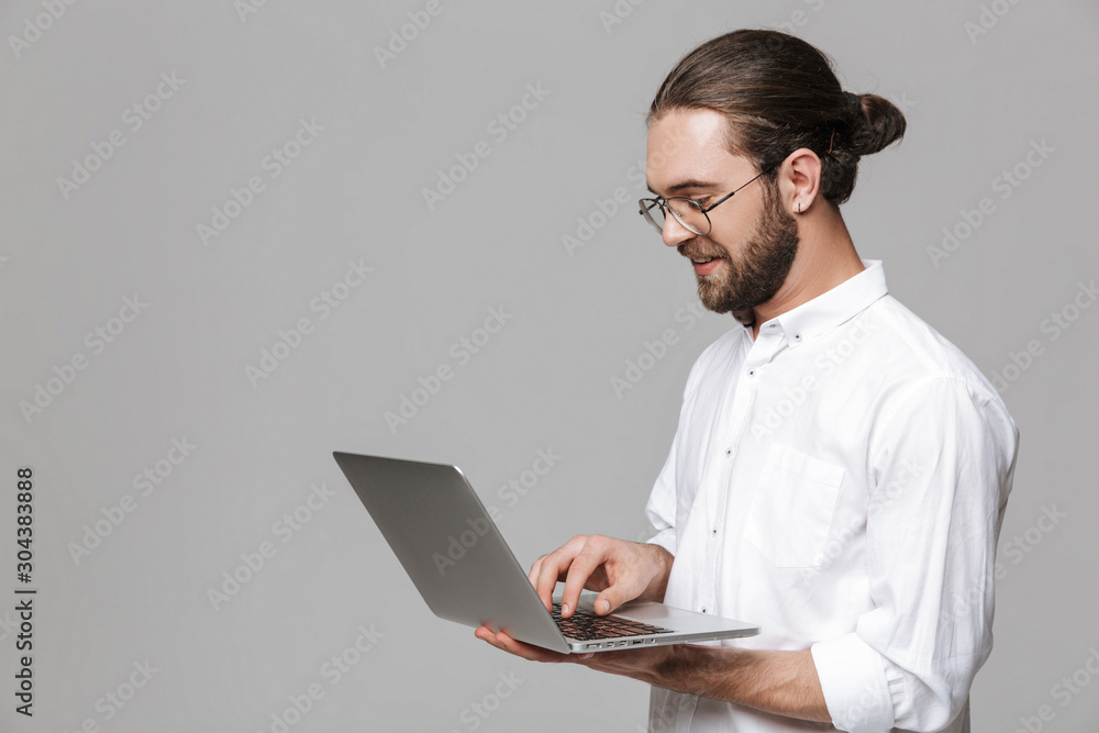 Handsome bearded man wearing glasses using laptop computer. Handsome bearded man wearing glasses using laptop computer.