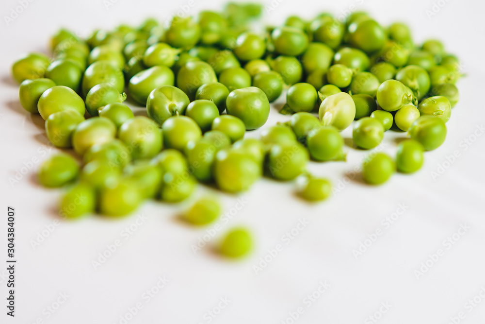 Fresh green peas scattered on a white background. Fresh green peas scattered on a white background.