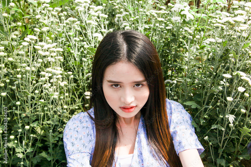 Portrait young beautiful asian woman in blue dress relaxing at chrysanthemum flower field Portrait young beautiful asian woman in blue dress relaxing at chrysanthemum flower field