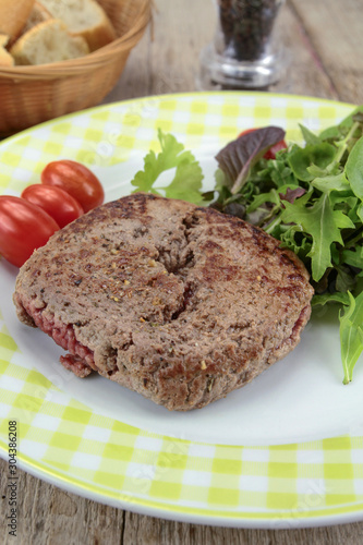 grilled ground beef steak and salad on a plate