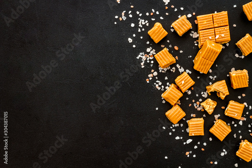 Foto Salted caramel pieces - paradoxical sweets - on black background top view copy s