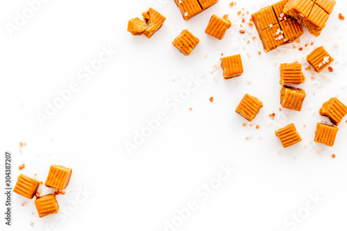 Konstfotografi Salted caramel pieces - paradoxical sweets - on white background top view frame