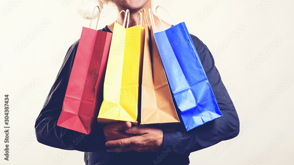 Man with packing bags. Seasonal sales. Black friday concept. Guy holds many shopping bags. Great shopping time and discounts for you