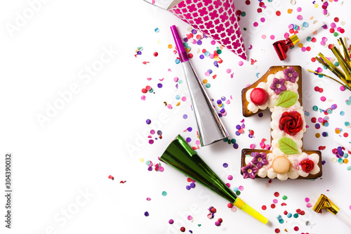Number one cake decorated with flowers, macarons and confetti isolated on white background. Copy space