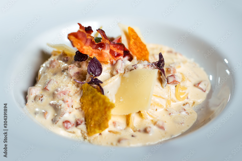 Potato gnocchi pasta with cheese sauce ham and basil on a plate. Potato gnocchi pasta with cheese sauce ham and basil on a plate.