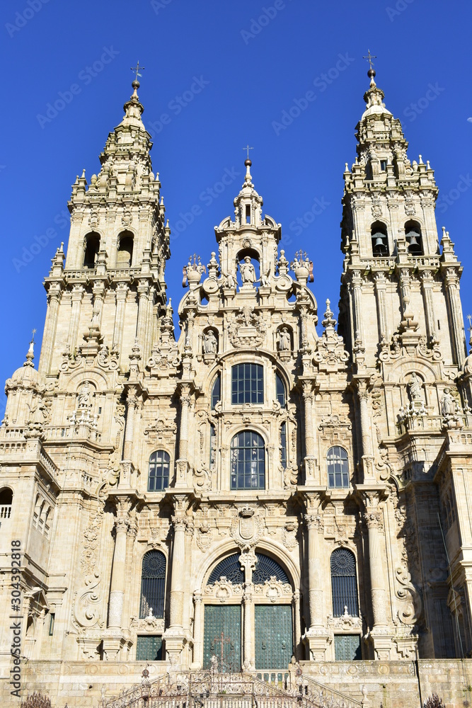 Cathedral, baroque facade and towers from Plaza del Obradoiro with blue sky. Santiago de Compostela, Spain.