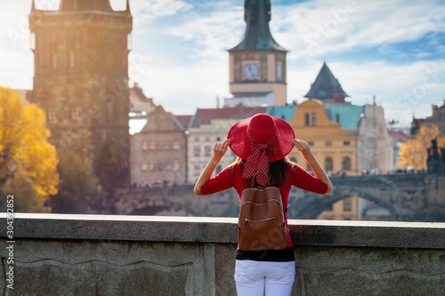 Touristin mit Hut genießt die Aussicht auf die Altstadt und Karlsbrücke von Prag, Tschechiche Republik photo