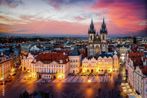 Prag am Abend: Blick auf die Marienkirche am alten Platz der Altstadt mit Lichtern und rotem Himmel, Tschechiche Republik