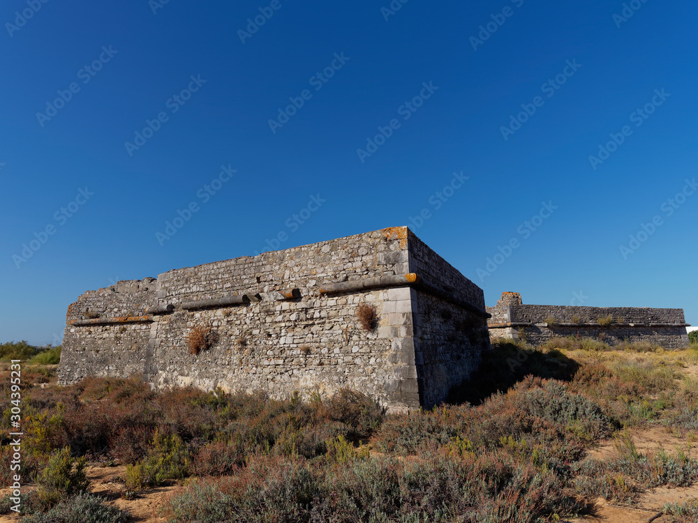 An old ruined and abandoned fort lying on the land behind the beach at Ilha da Culatra on Portugals Algarve Coast.
