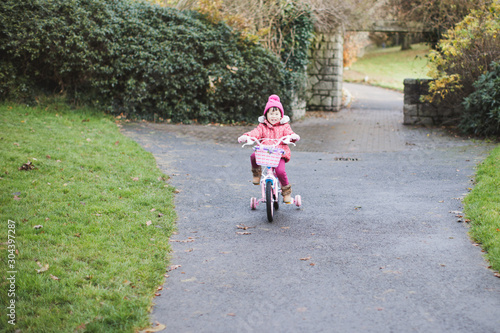 toddler girl ridding bicycle in winter countryside park,Northern Ireland