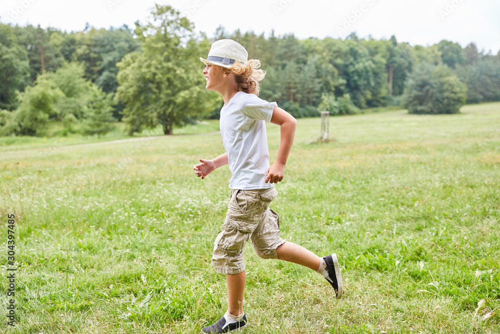Blond boy is running across a meadow Blond boy is running across a meadow