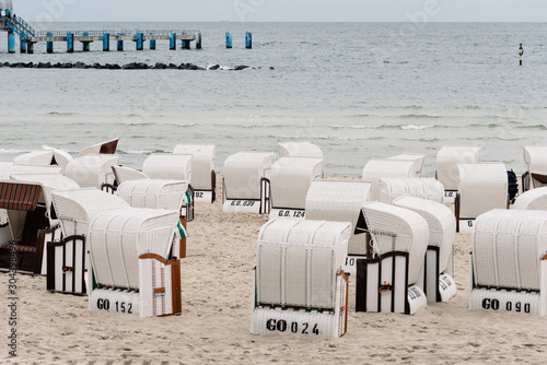 Hooded beach chairs in Baltic sea beach a cloudy day of Summer. Sellin, Rugen Island. Germany photo