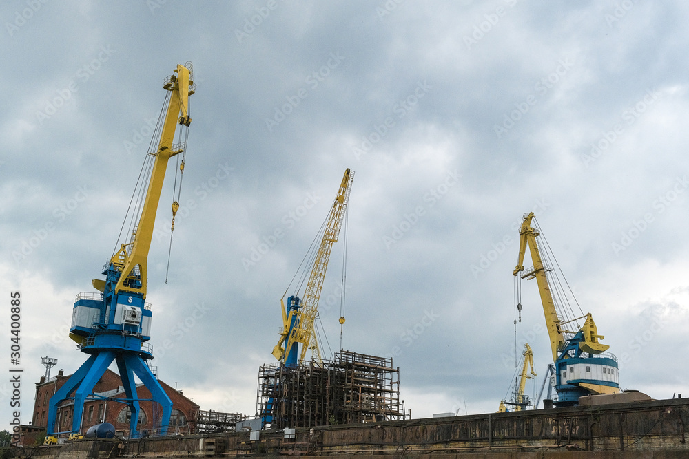 the gantry crane working at the seaport against the clouds the gantry crane working at the seaport against the clouds