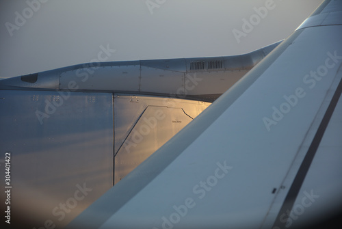 NB__7533 Aircraft engine and wing part during flight in sunset