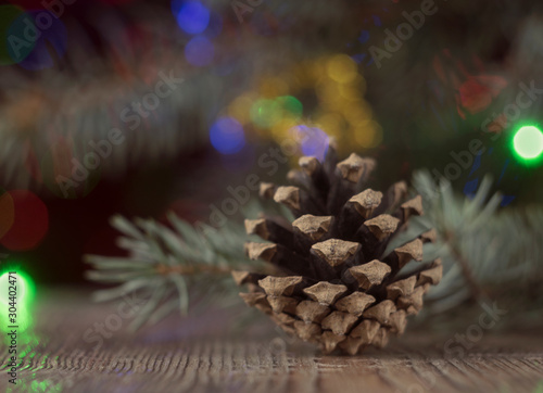 Composition from a still life for the holiday of Christmas and New Year. Fir cones, garlands and candles, as well as a Christmas tree with Christmas decorations