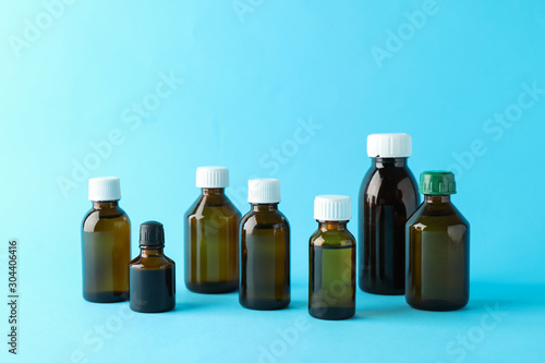 Brown glass medical bottles on blue background, space for text
