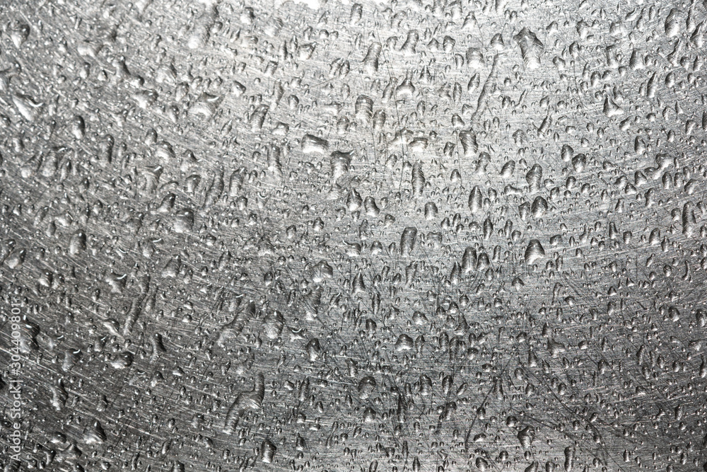 Drops of water on a scratched metal background closeup Drops of water on a scratched metal background closeup