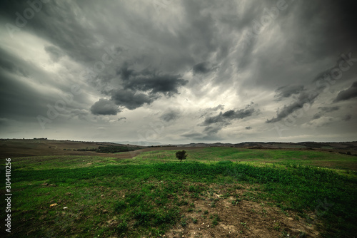 Dramatic sky over a green field in Tuscany