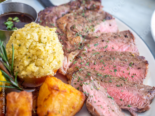 Ribeye beef steak medium to well done grilled served with corn, pototoes and asparagus in restaurant photo