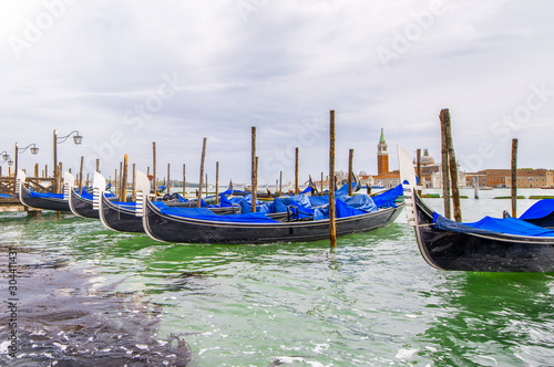 Gondolas boats along city pier, Venice, Italy
