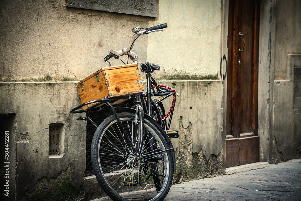 Old bike with wooden case leaning against a wall in Florence Old bike with wooden case leaning against a wall in Florence