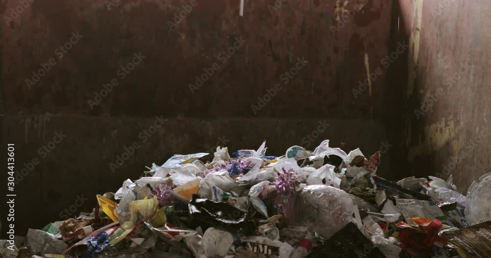 Problem of recycling and environmental pollution. Non sorting different garbage falling in container for transportation and waste processing. Food and plastic waste, clothes on urban refuse plant. Problem of recycling and environmental pollution. Non sorting different garbage falling in container for transportation and waste processing. Food and plastic waste, clothes on urban refuse plant.