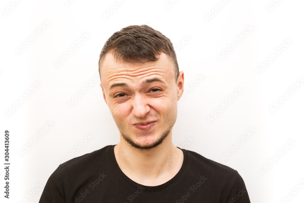 Obraz premium emotion grimacing, young man in a black cap on a white background, man emoji