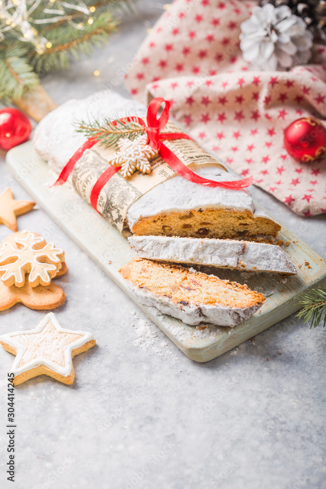 Stollen a traditional European cake with nuts and candied fruit, is dusted with icing sugar and cut into pieces Stollen a traditional European cake with nuts and candied fruit, is dusted with icing sugar and cut into pieces