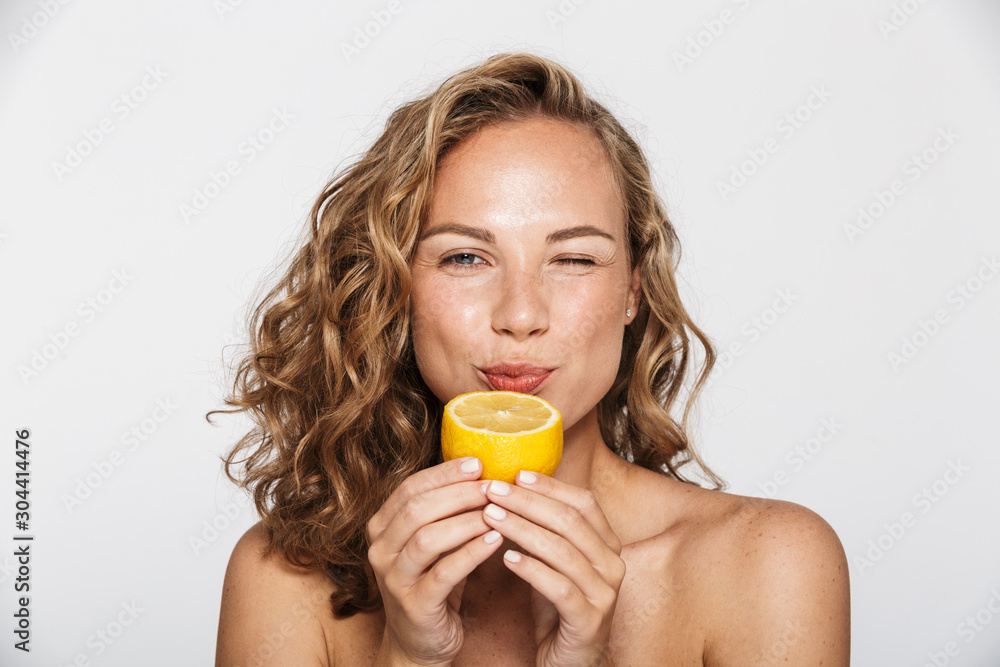 Image of attractive half-naked woman winking and eating lemon Image of attractive half-naked woman winking and eating lemon
