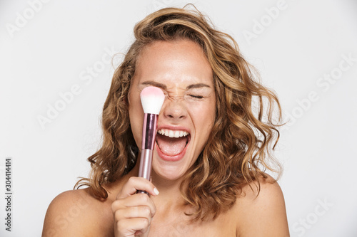 Tableau sur toile Image of half-naked woman making fun with makeup brush and screaming