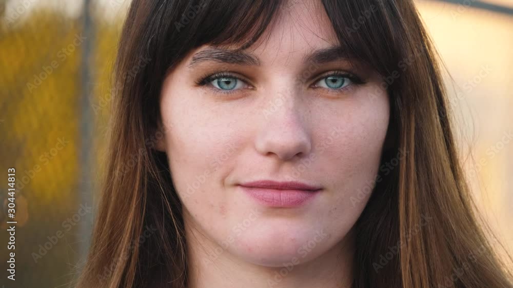 Close up portrait of woman with beautiful blue eyes, long brown hair look at camera. With smile, natural skin and less make up. Close up portrait of woman with beautiful blue eyes, long brown hair look at camera. With smile, natural skin and less make up.