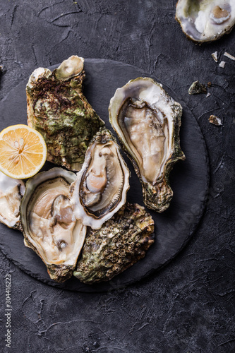 Fresh open Oysters. Healthy sea food. Dinner in restaurant. Gourmet food. Dark background. Top view