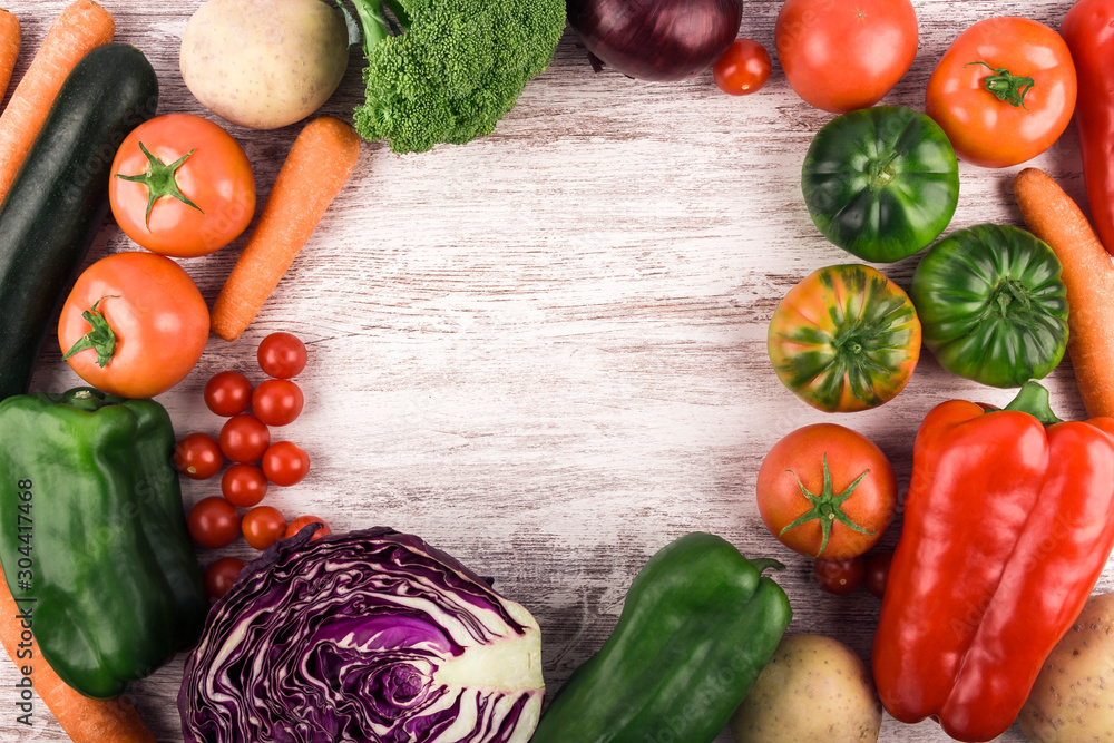 Top view of fresh and healthy raw vegetables placed in a circle to leave a space for text or an image. Rustic white wood background. Copy space. Healthy food. Natural products. Nature and well-being Top view of fresh and healthy raw vegetables placed in a circle to leave a space for text or an image. Rustic white wood background. Copy space. Healthy food. Natural products. Nature and well-being