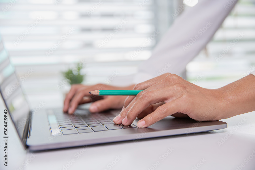 Business Woman or accountant.The laptop is on the table. Rest their hands on a laptop with a pencil Business planning Financial accountants work and calculate annual financial statements.. Business Woman or accountant.The laptop is on the table. Rest their hands on a laptop with a pencil Business planning Financial accountants work and calculate annual financial statements..
