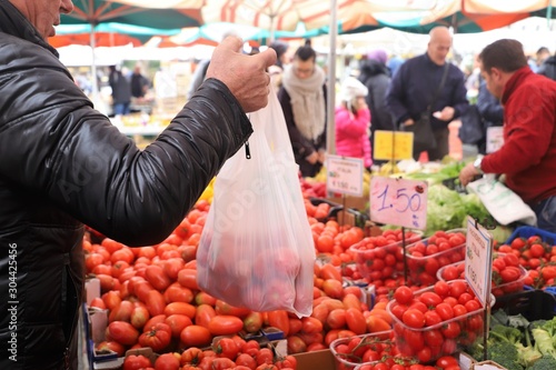 Obraz na plátně closeup of a hand taking a tomato from a market stall