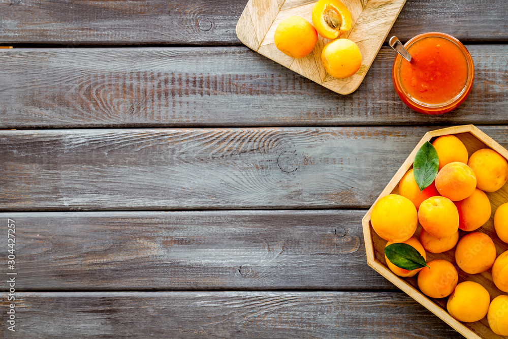 Healthy breakfast. Apricot jam in jar near fresh fruits on dark wooden background top view frame copy space Healthy breakfast. Apricot jam in jar near fresh fruits on dark wooden background top view frame copy space