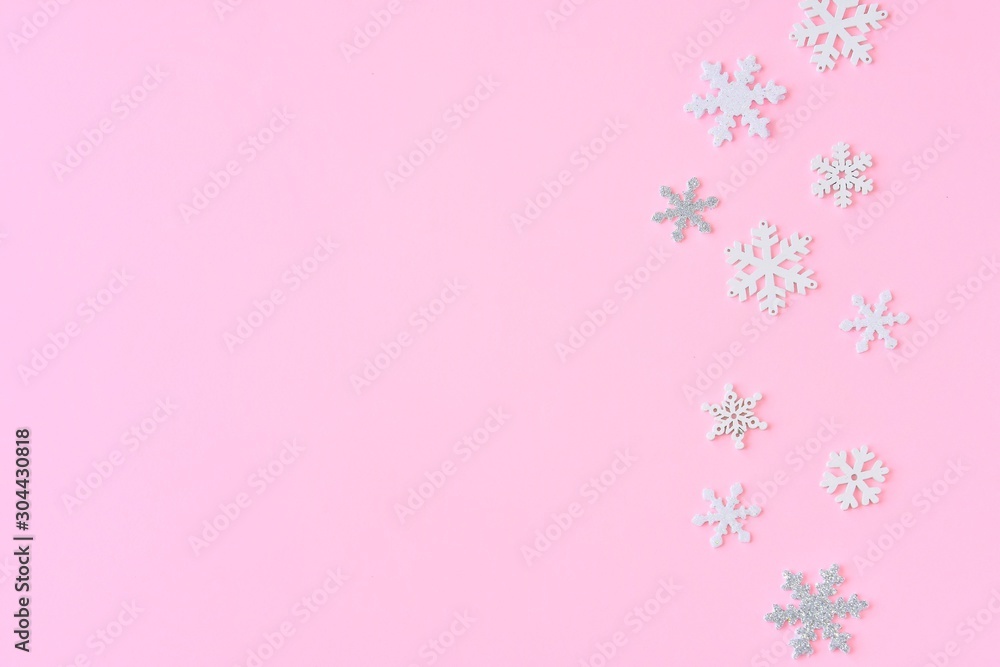 Pink Christmas background with white and silver snowflakes border and empty space for text, selective focus. New year flat lay with snowflakes decorative border. Winter postcard. Pink Christmas background with white and silver snowflakes border and empty space for text, selective focus. New year flat lay with snowflakes decorative border. Winter postcard.