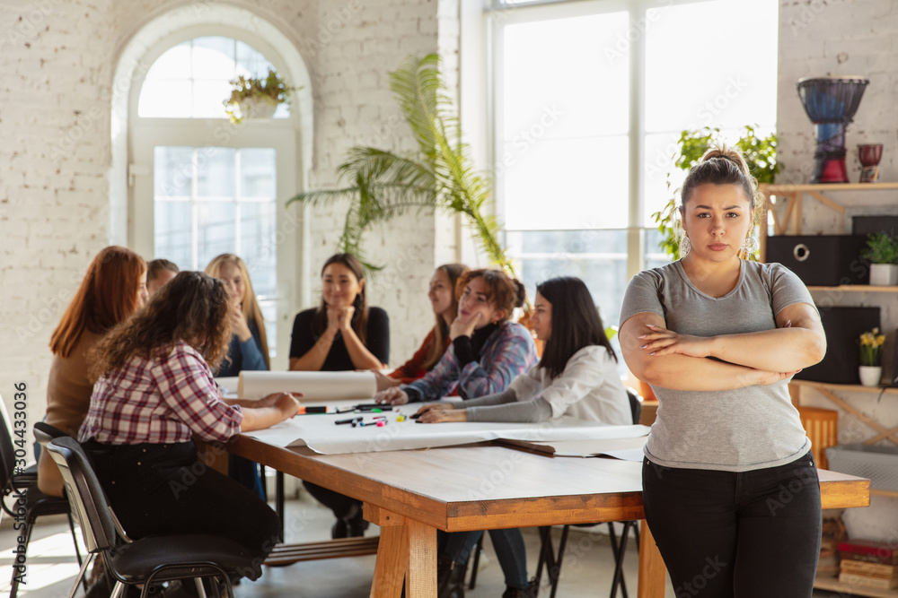 Women's rights and equality at the office. Caucasian businesswomen or young confident model crossed hands in front of coworkers having meeting about problem in workplace, male pressure and harassment. Women's rights and equality at the office. Caucasian businesswomen or young confident model crossed hands in front of coworkers having meeting about problem in workplace, male pressure and harassment.