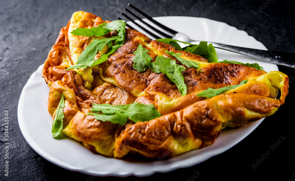 omelet in white plate on Dark grey black slate background omelet in white plate on Dark grey black slate background