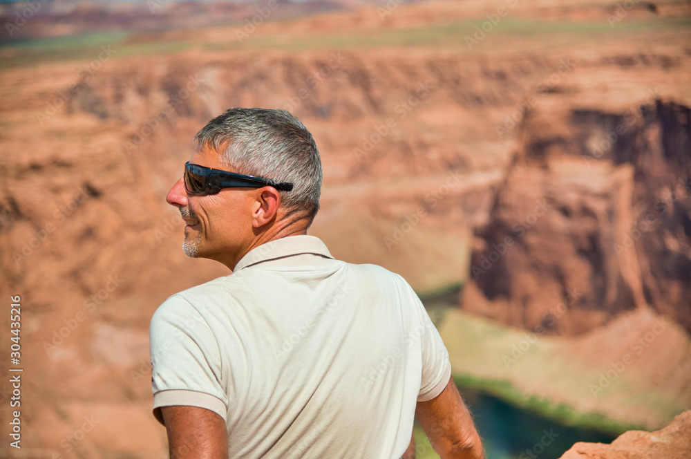 Back view of man mesmerized by Horseshoe Bend view