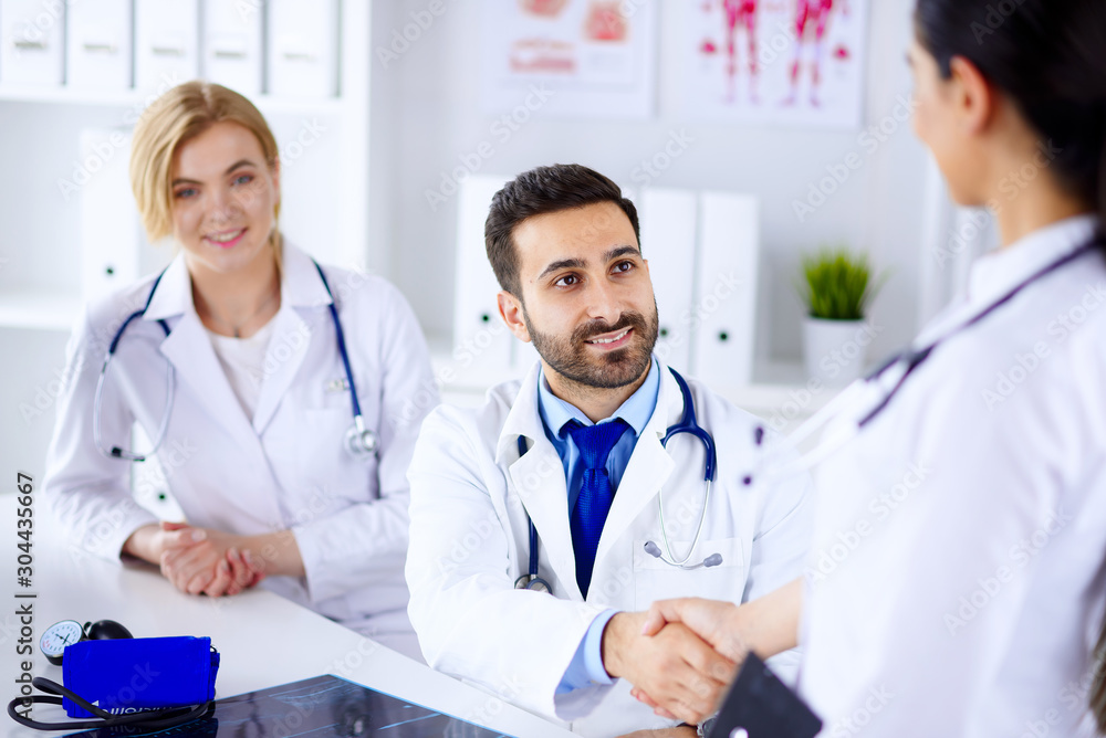 Doctors in the office communicate and shake hands. Doctors in the office communicate and shake hands.