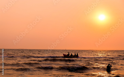 Beautiful natural view .sunset on the beach.People sitting on a boat. © Pornsuda