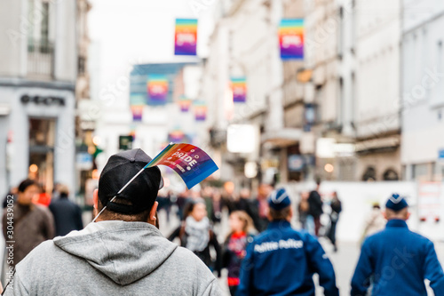 Brusseles, Belgium - May 2019: Symbol of the LGBT parade "Belgium pride" paper flag sticking out of a passer‚Äôs cap. View from the back