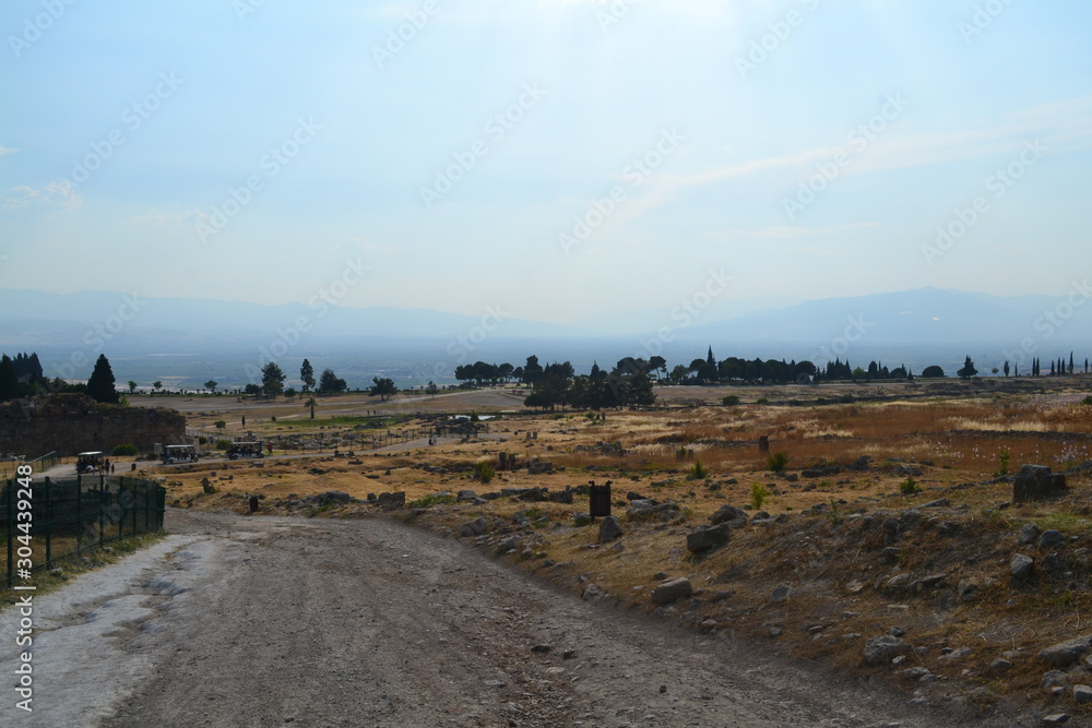 Fototapeta premium Old Hierapolis ruins, amphitheatre and touristic locations captured with hill background, in daytime.