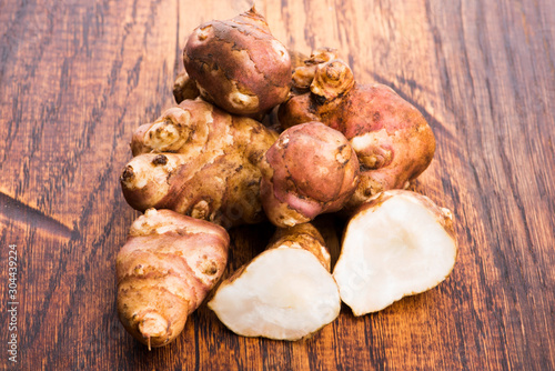 Raw Whole ans sliced Jerusalem artichokes on a cutting board