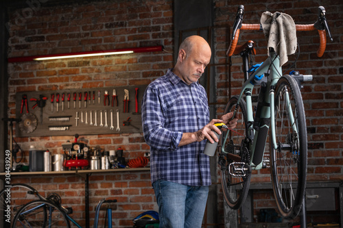 Wallpaper Mural Man oiling the chain on a bicycle in a workshop Torontodigital.ca