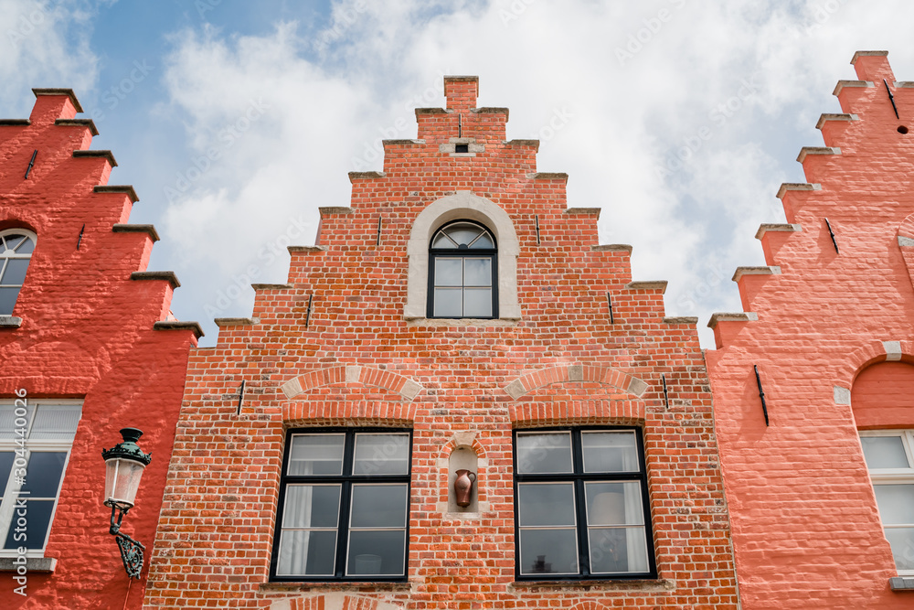 The traditional facades of brick houses in Bruges. Red, orange, salmon shades.