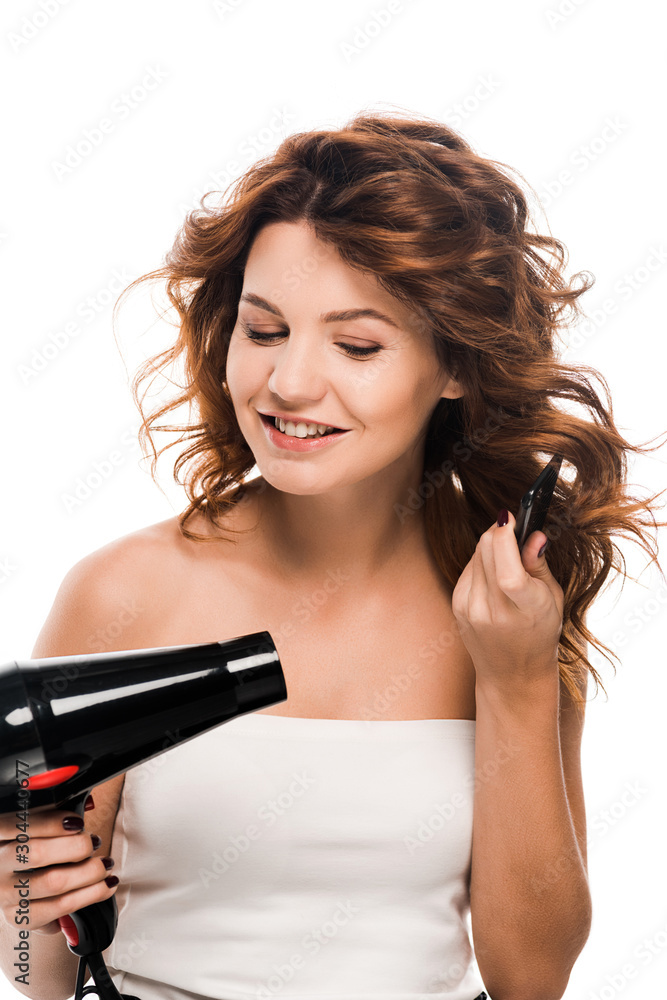 happy girl using hair dryer while brushing hair isolated on white happy girl using hair dryer while brushing hair isolated on white