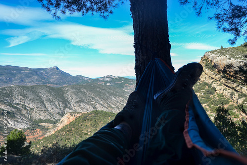 view of the feet and the landscape from a hanging hammock on top of a mountain resting on vacation landscape