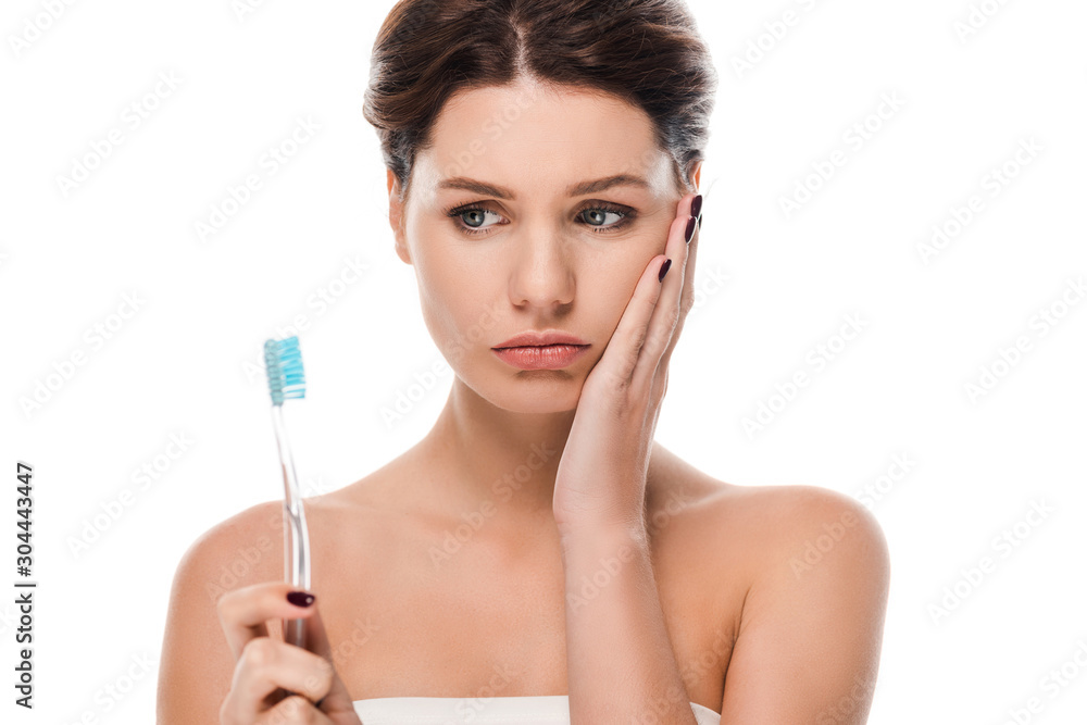 sad young woman touching face while holding toothbrush isolated on white sad young woman touching face while holding toothbrush isolated on white